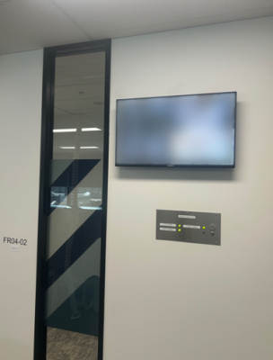 Photo of a CCTV display mounted to the wall about an alarm panel.