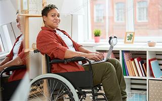 women in wheelchair communicating on laptop